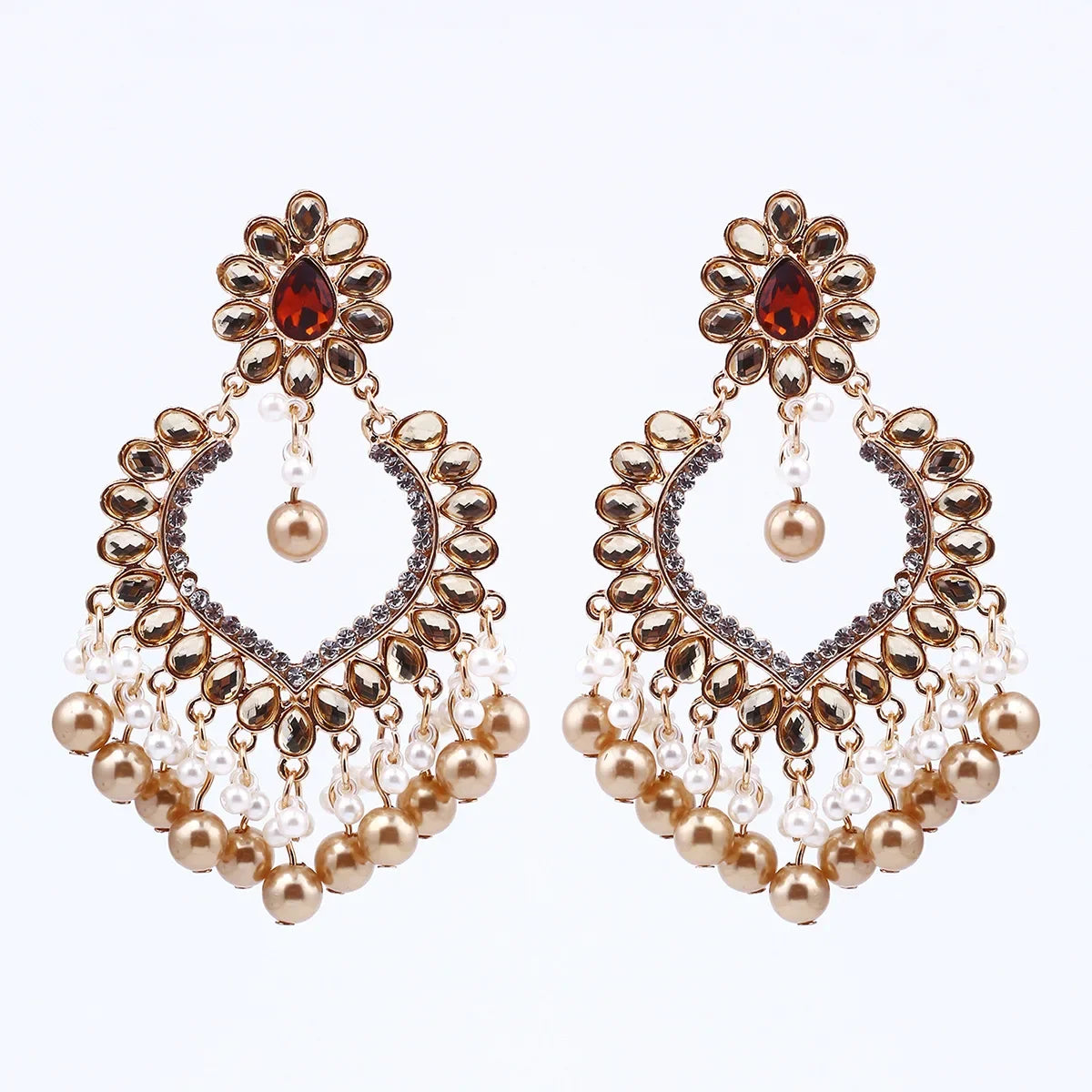 Pair of ornate earrings with pearls and gemstones on a white background