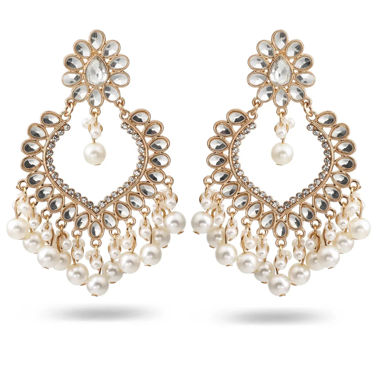 Pair of ornate earrings with pearls on a white background